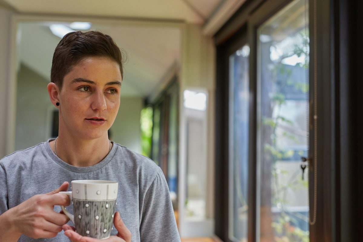 Ettertenksom person med kaffekopp ved vinduet i rolig dagslys – det finnes hjelp å få